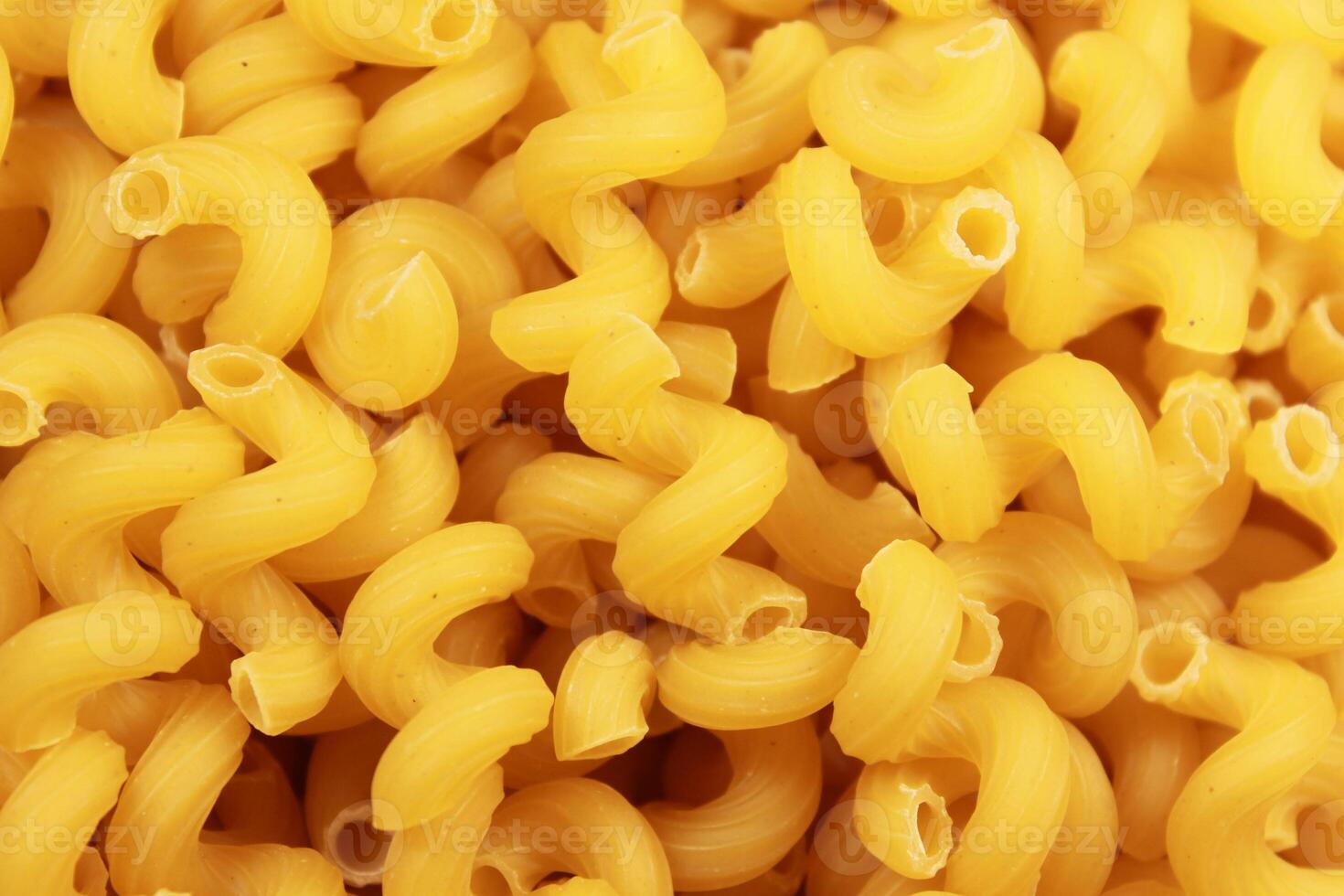 Close-up of dry uncooked cellentani pasta, top view. photo