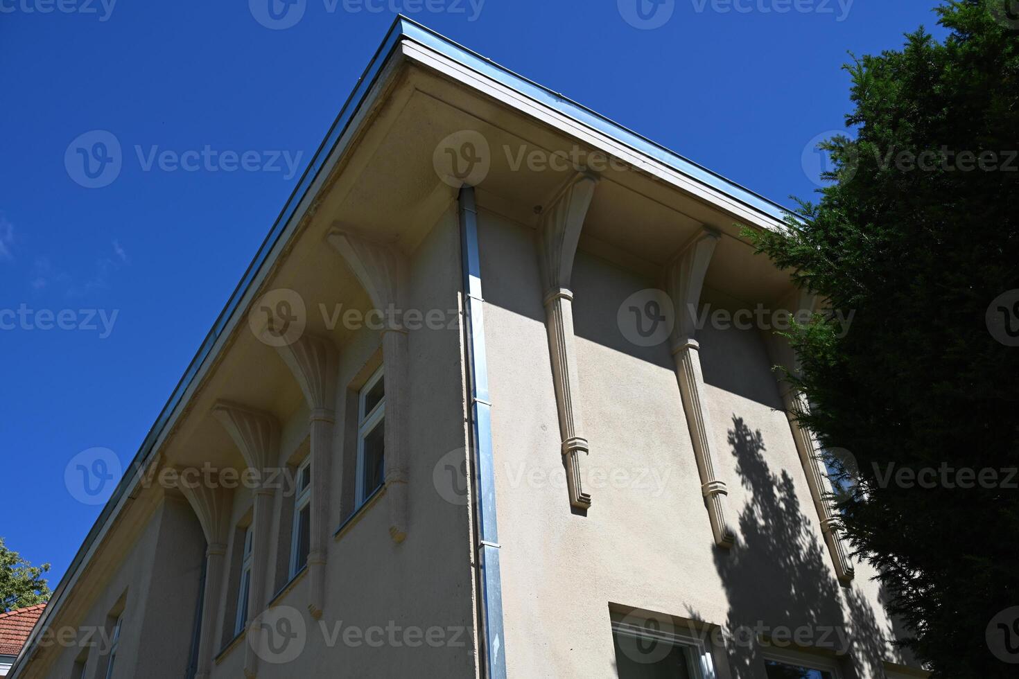 a building with a blue sky and a tree photo