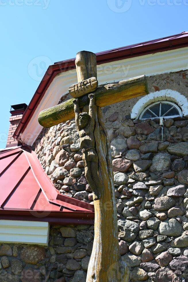 a wooden cross on a stone wall photo