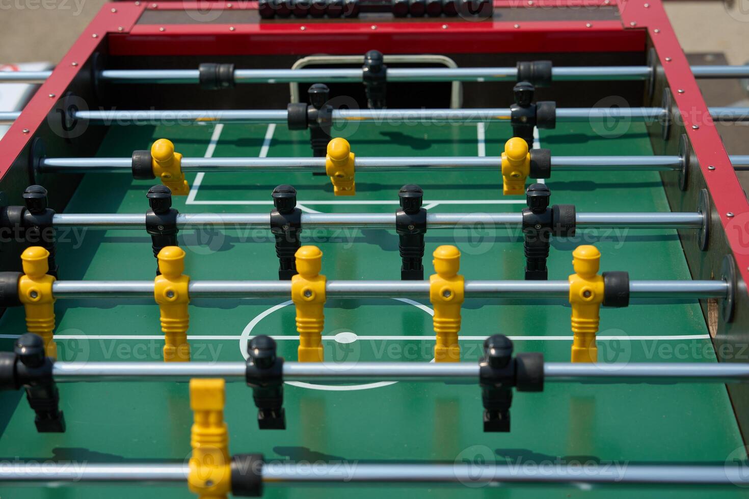 Foosball table game with player figures, handles, spinning rods. Foosball table game match players soccer ball. photo
