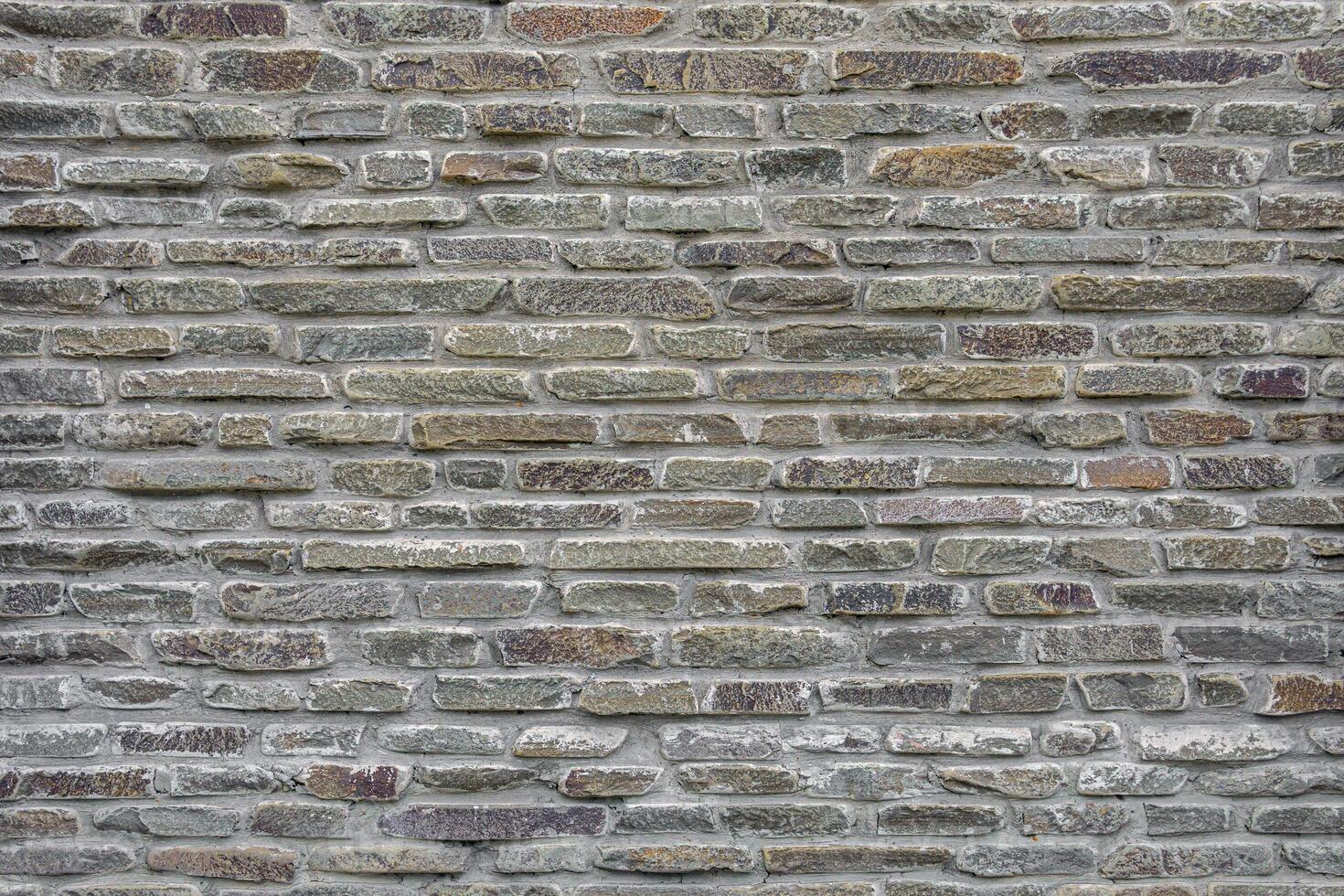 The wall of the castle is made of uneven, flat stones of various dark shades. photo
