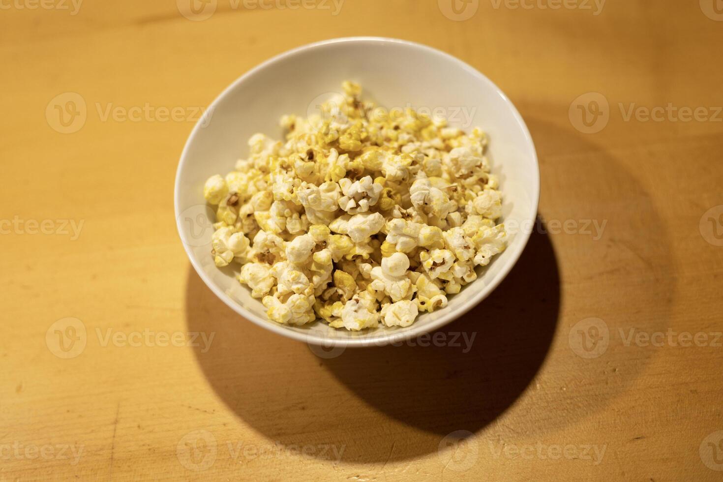 popcorn in a white plate on the table, movie time photo