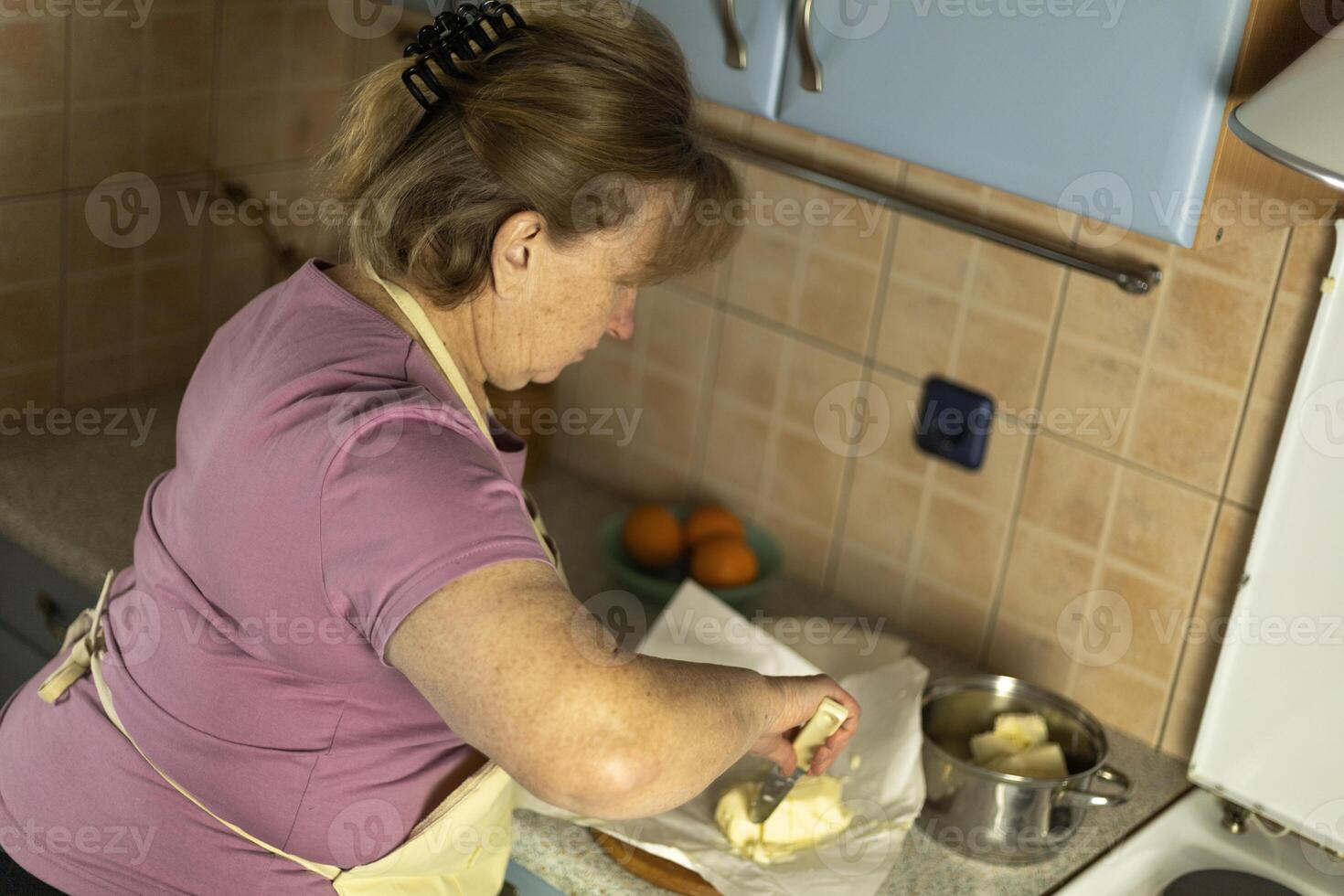 A senior woman is preparing sweet butter to make ghee. photo