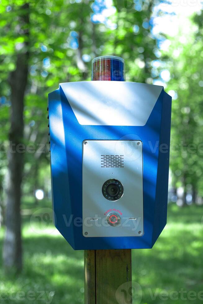 Panic alarm for call to police, emergency button in public park. photo
