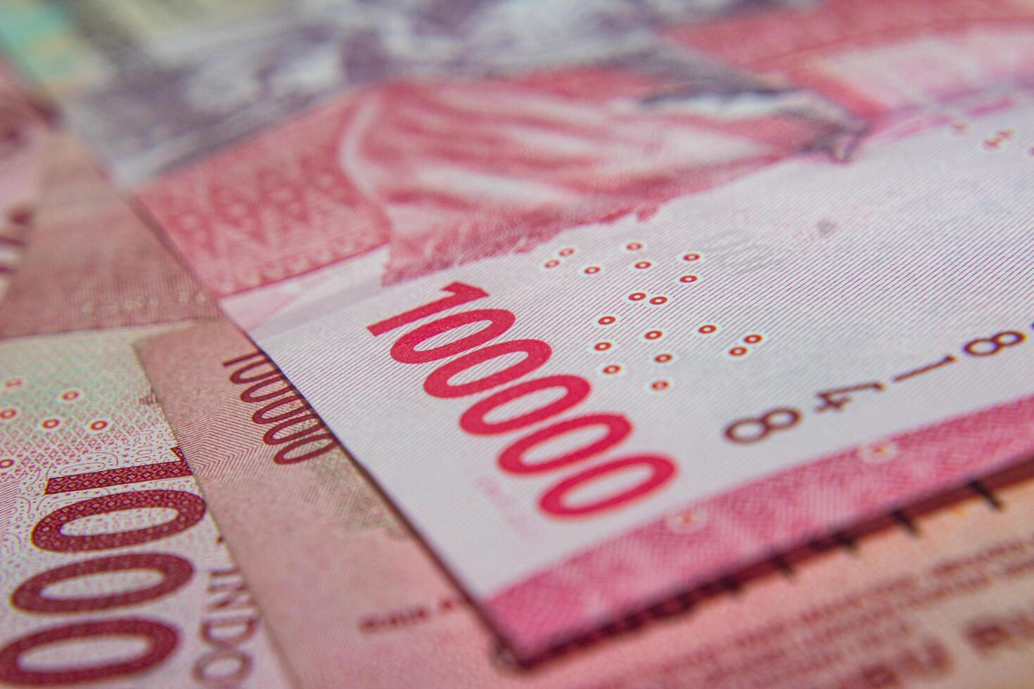 Close-up of Indonesian 100,000 Rupiah banknotes in pink tones photo