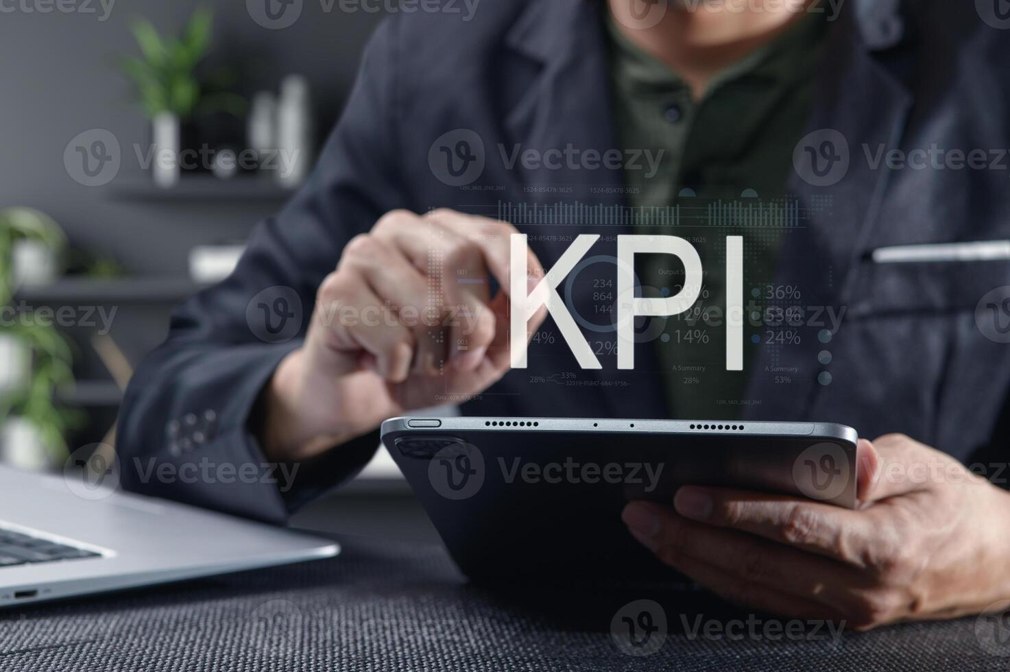 Businessman Analyzing Key Performance Indicators on Tablet Device photo