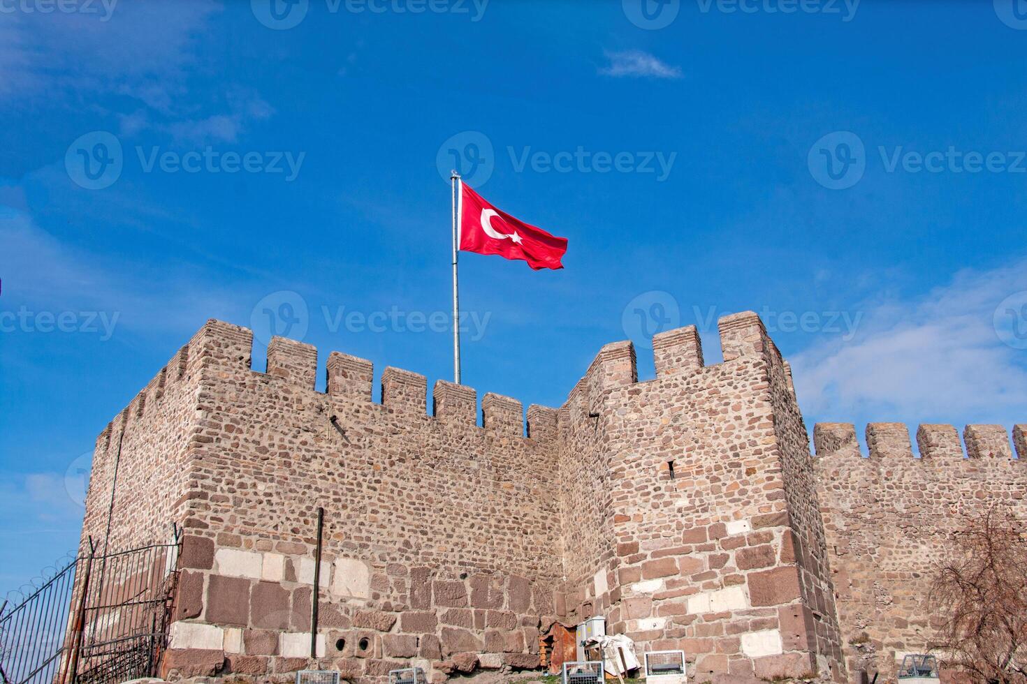 Turkish Flag Flies High Above Ancient Stone Fortress Wall photo