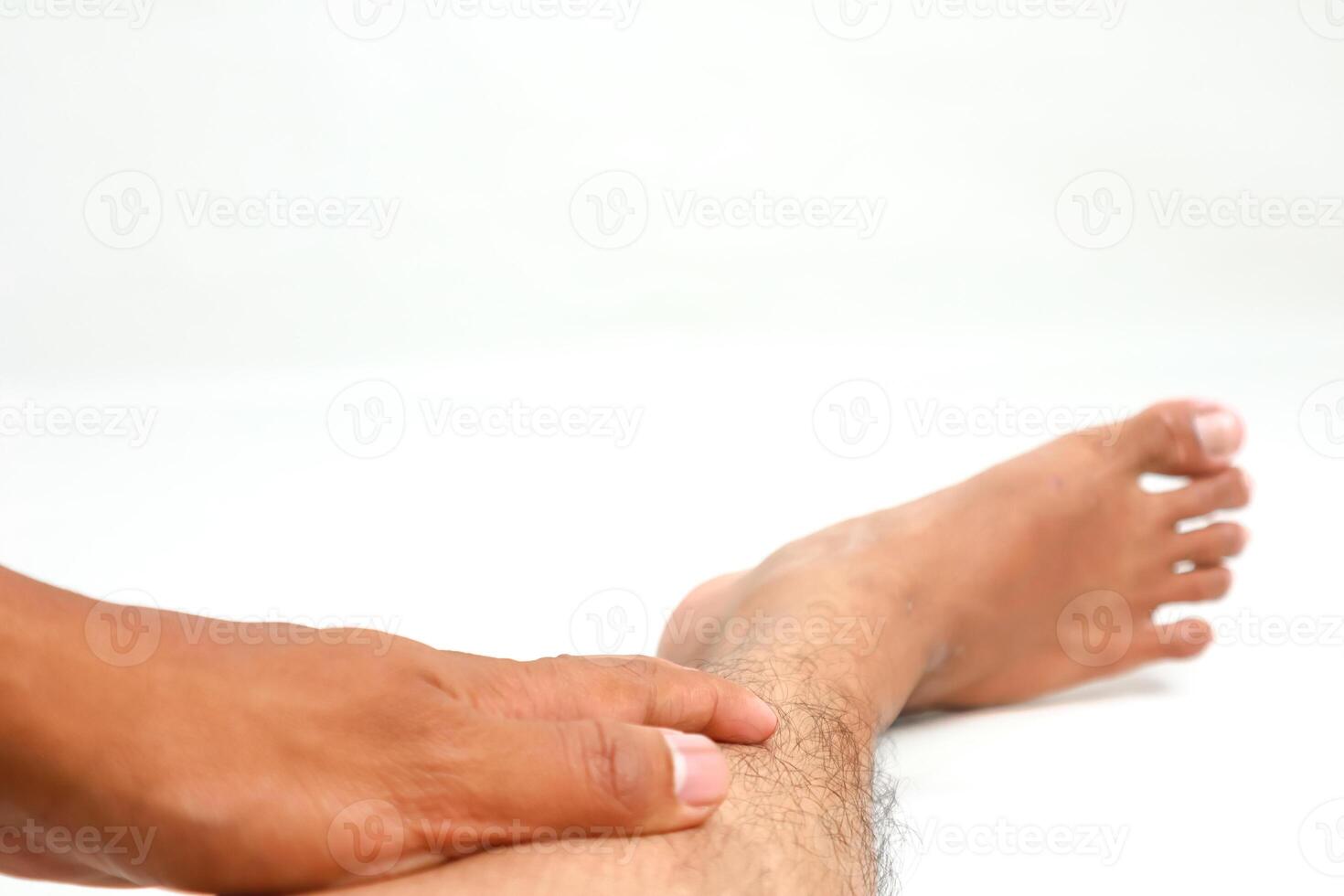 Close-up of a Man's Hand Massaging or Checking His Ankle for Pain or Injury Isolated on White photo