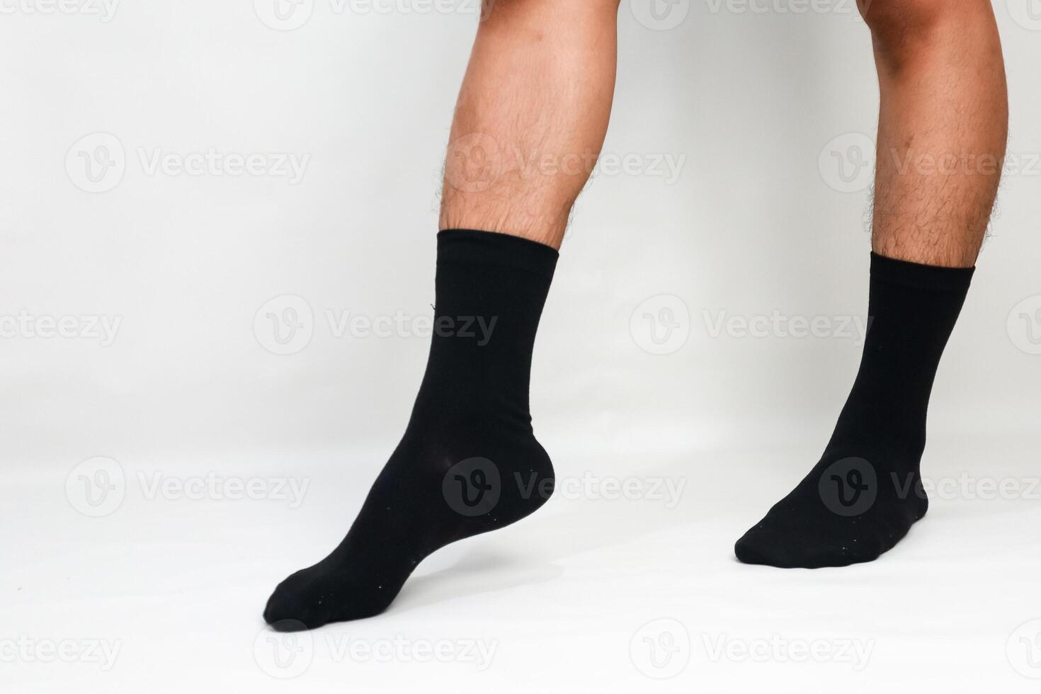 Close-up shot of a man's legs wearing black socks against a plain white background, showcasing fashion and comfort photo