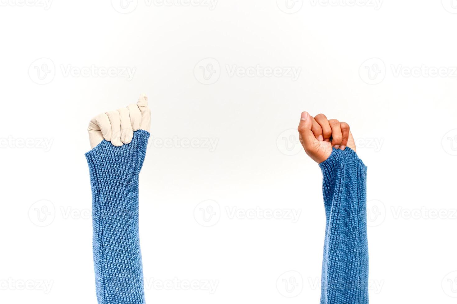 Diversity in unity, two hands raised in solidarity wearing blue knit sleeves against white background photo