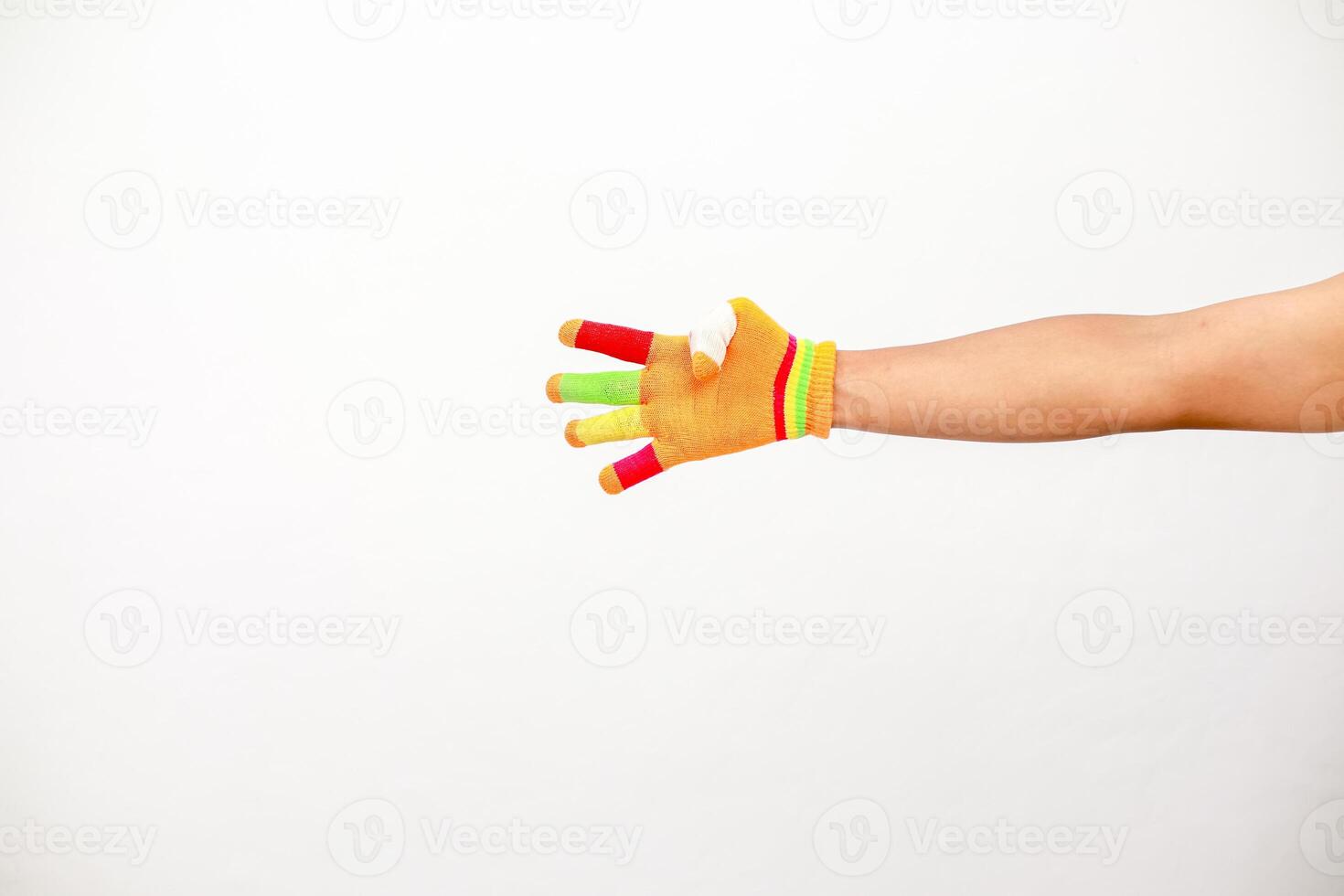 Hand with colorful finger glove on white background, showcasing playful fashion and creative expression against clean backdrop photo