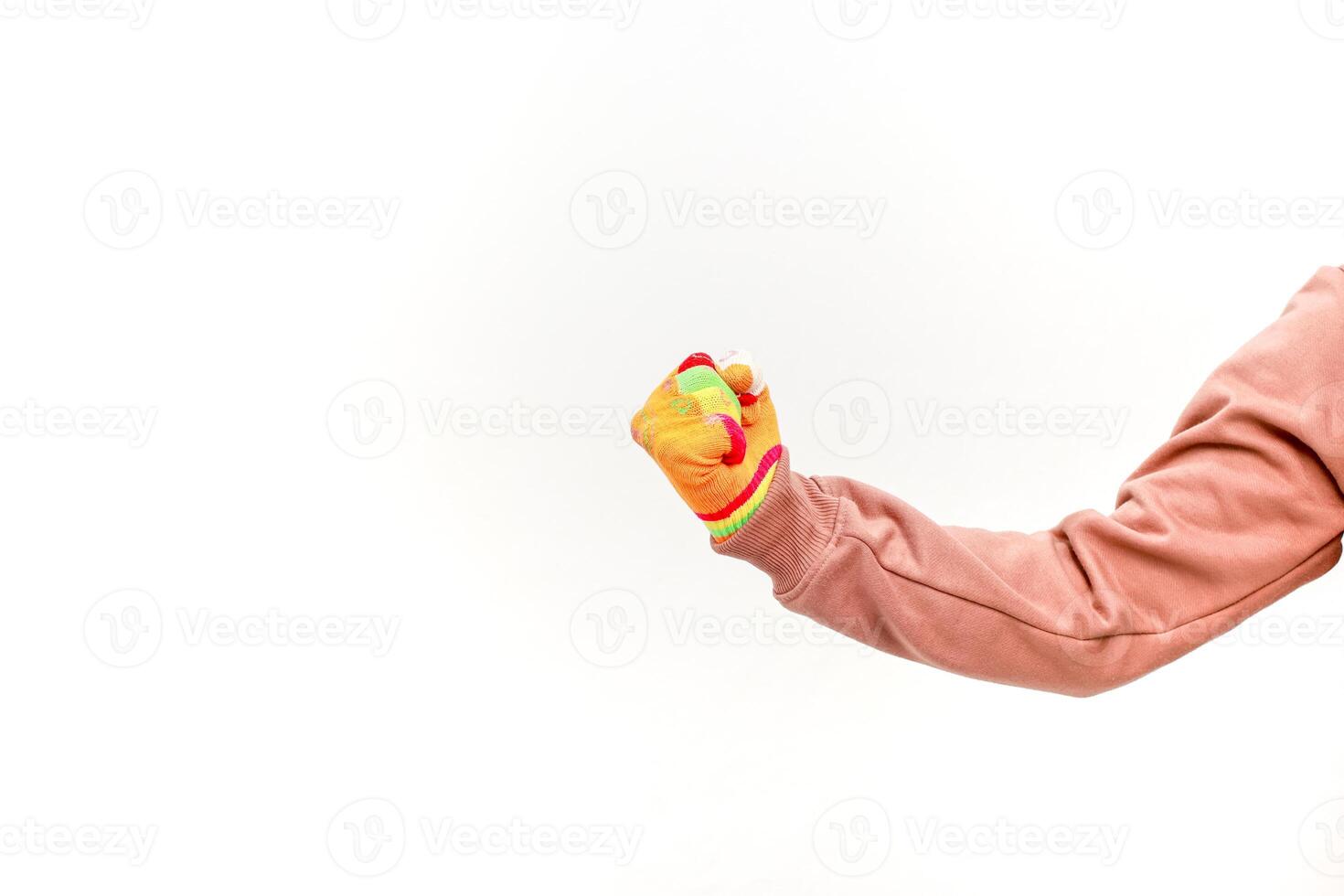 A clenched fist wearing a vibrant gardening glove symbolizing strength and determination against white backdrop photo