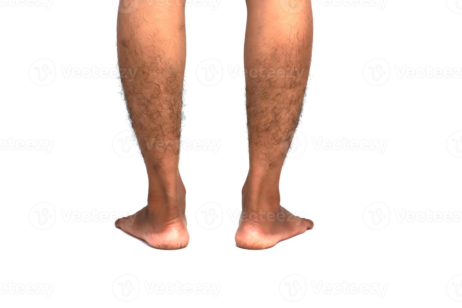 A close-up shot of the lower legs and feet of a man, focusing on skin texture and hair, on a plain white background photo