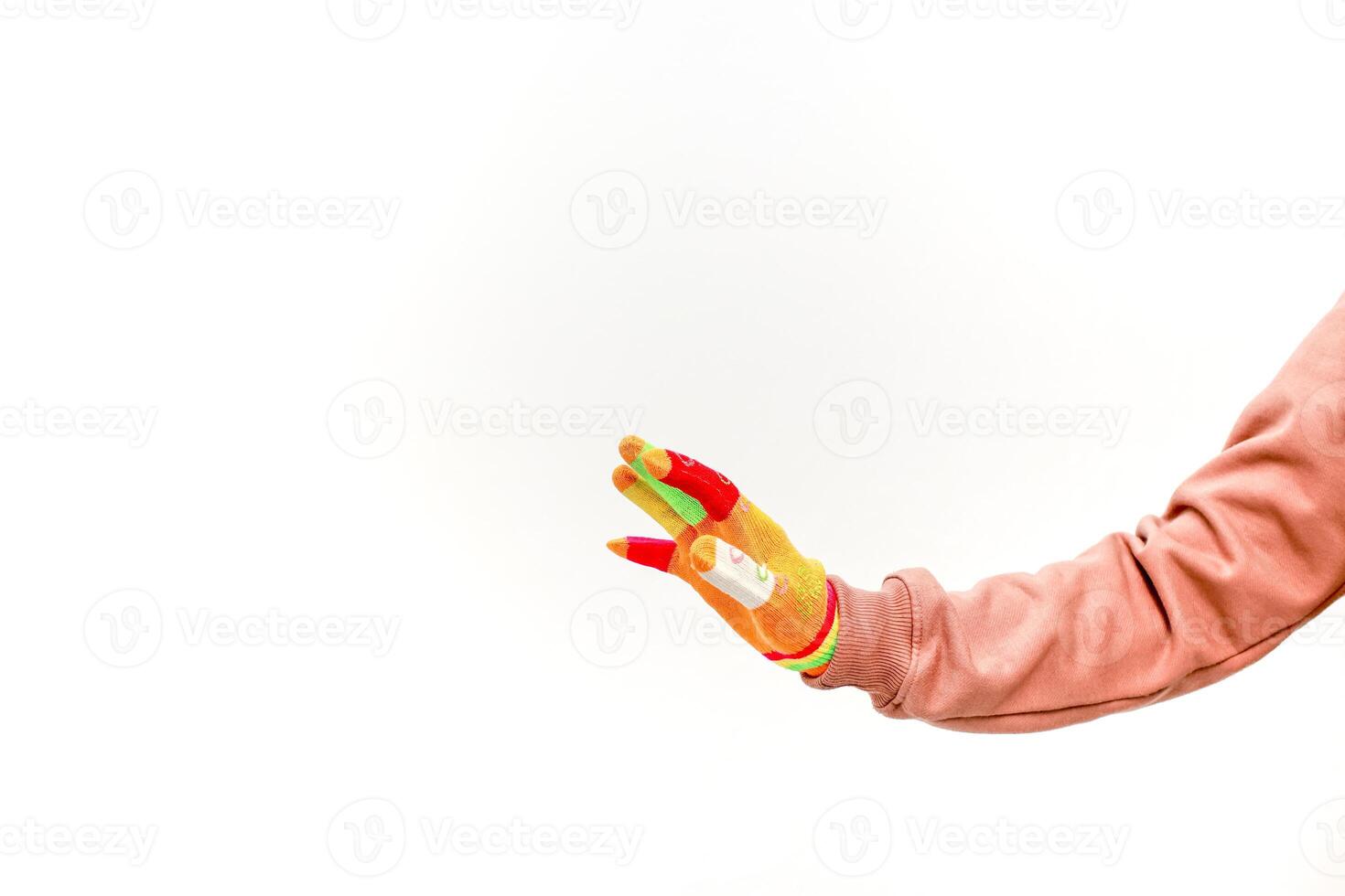A colorful gloved hand with a bandage reaching out on a white background creates a playful and vibrant visual photo