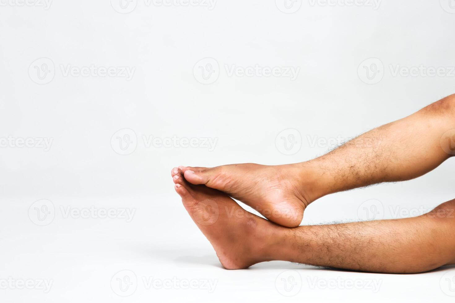 Close-up of Relaxed Male Legs and Feet on a White Background, Showcasing Skin Tone and Texture photo