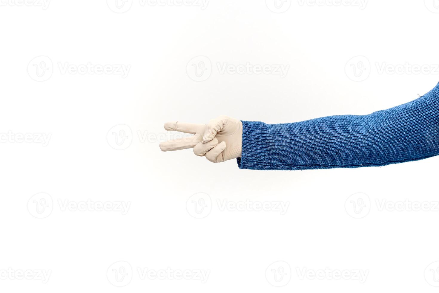 Arm wearing a blue sweater and surgical glove making a peace sign on white background photo
