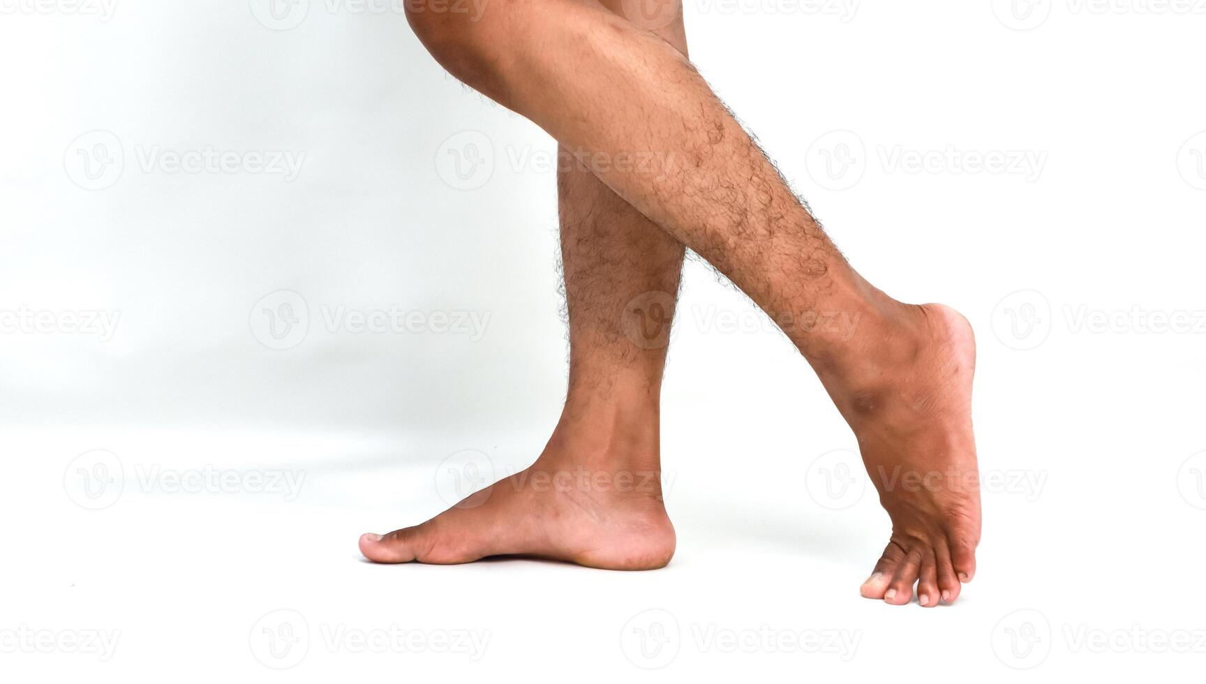 Studio shot of dark-skinned legs in motion, showcasing a step forward against a clean white backdrop photo