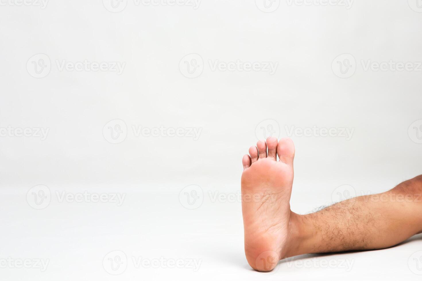 Close-up of a bare male foot on a white background, showcasing foot care and anatomy in a simple, isolated setting photo