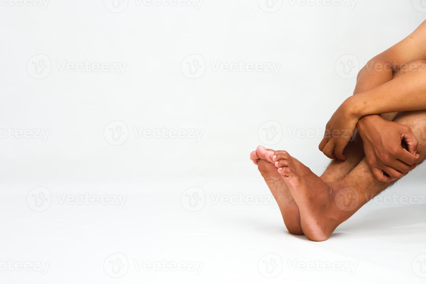 Isolated image capturing a person in seated fetal position with focus on feet and hands photo