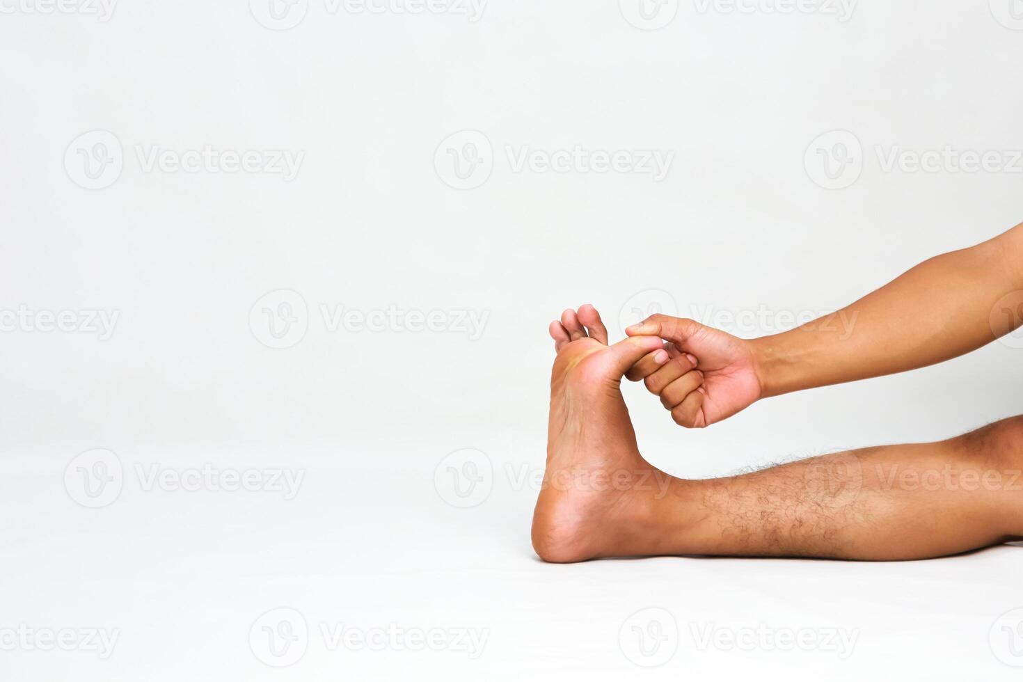 Man stretching foot and toes, demonstrating flexibility and promoting foot health on a white background photo