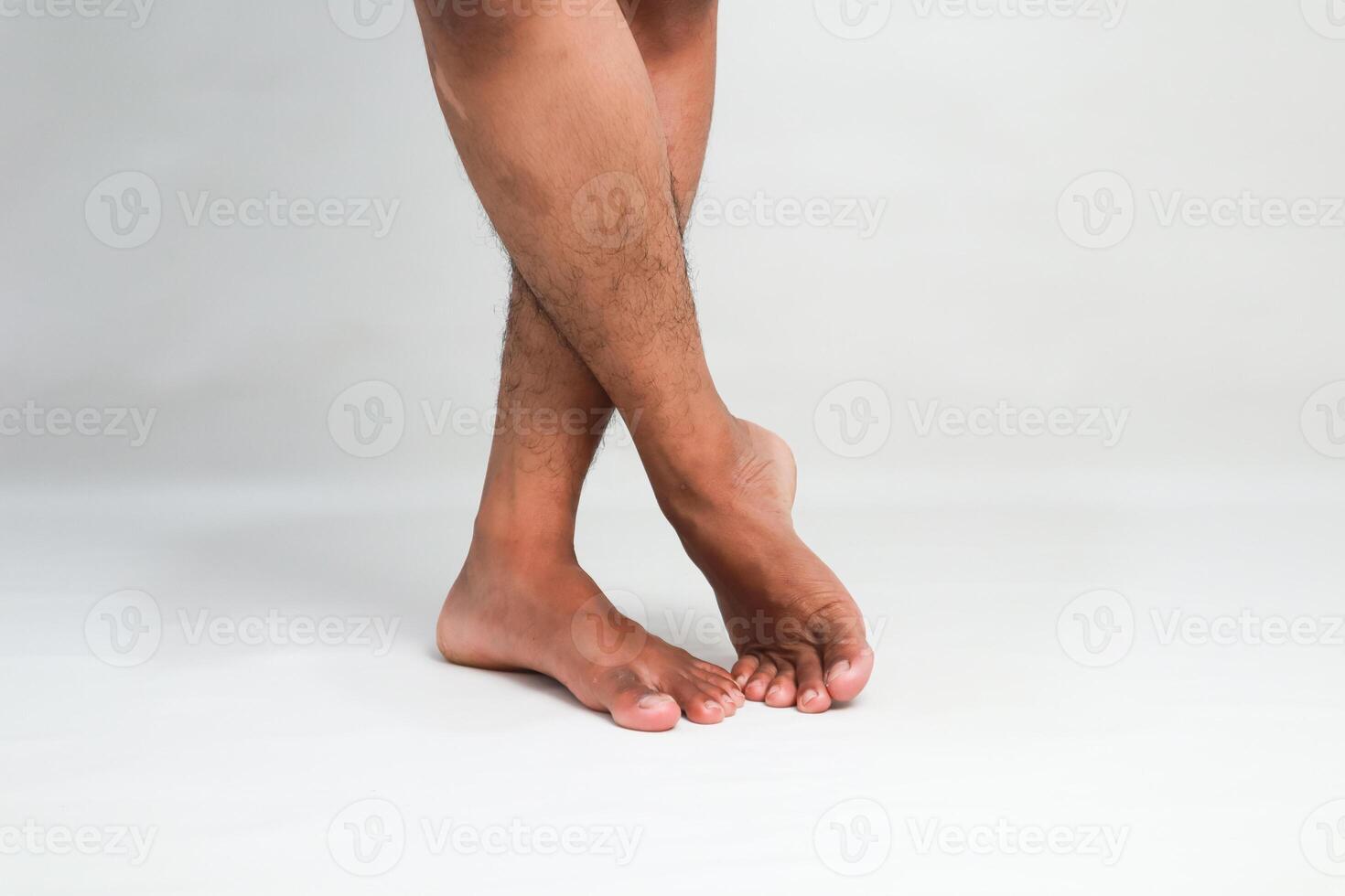 A Pair of Crossed Legs and Bare Feet on a White Background Evoking Relaxation and Elegance photo