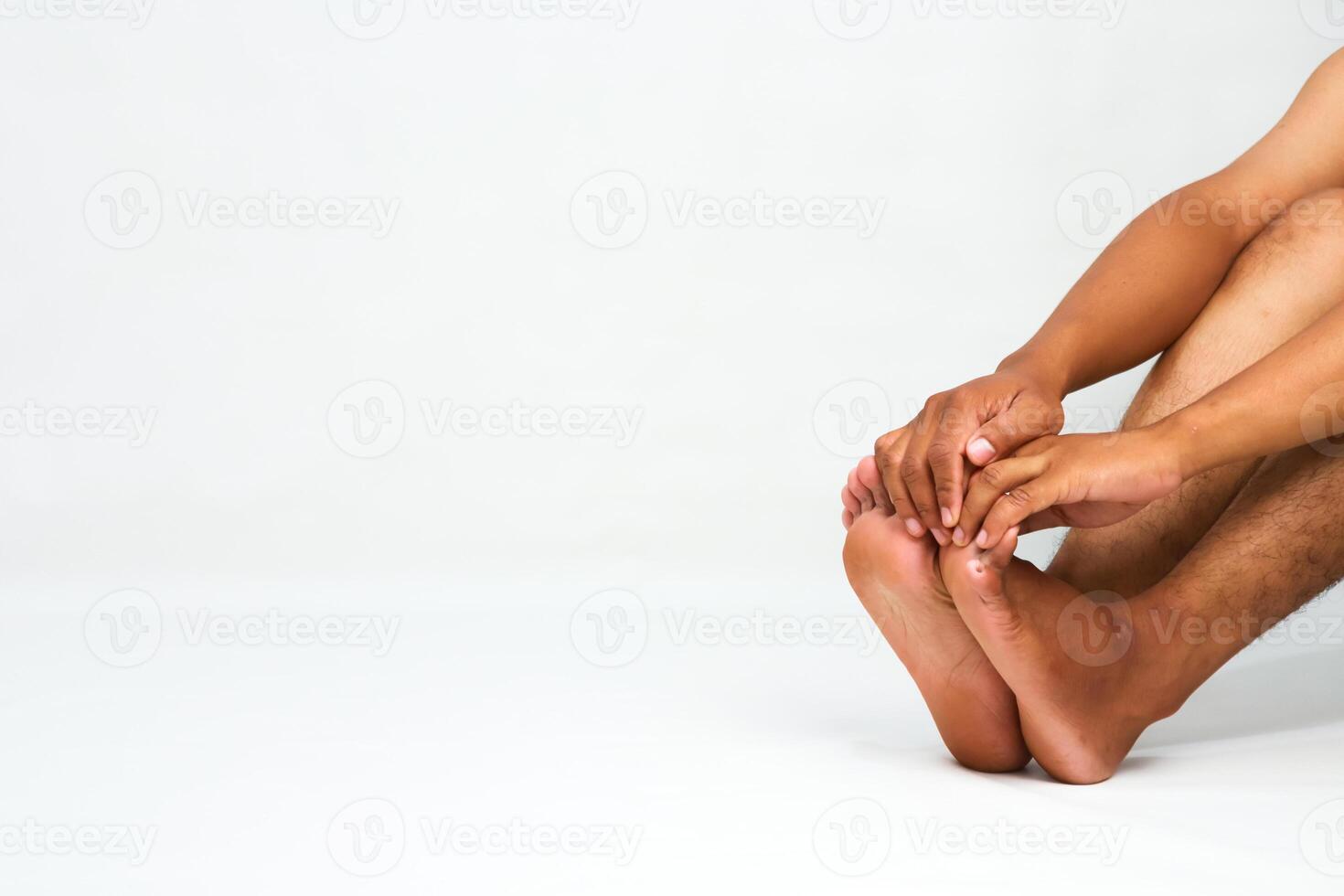 Close-up of a person holding their feet, possibly due to pain or discomfort photo