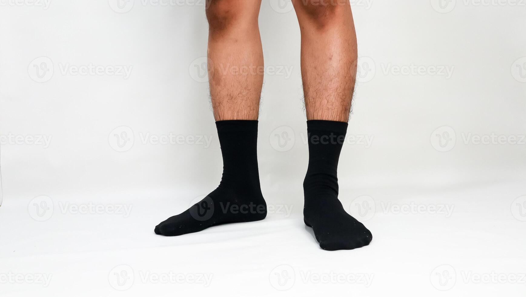 Male legs wearing black socks on a white background highlighting fashion and comfort photo