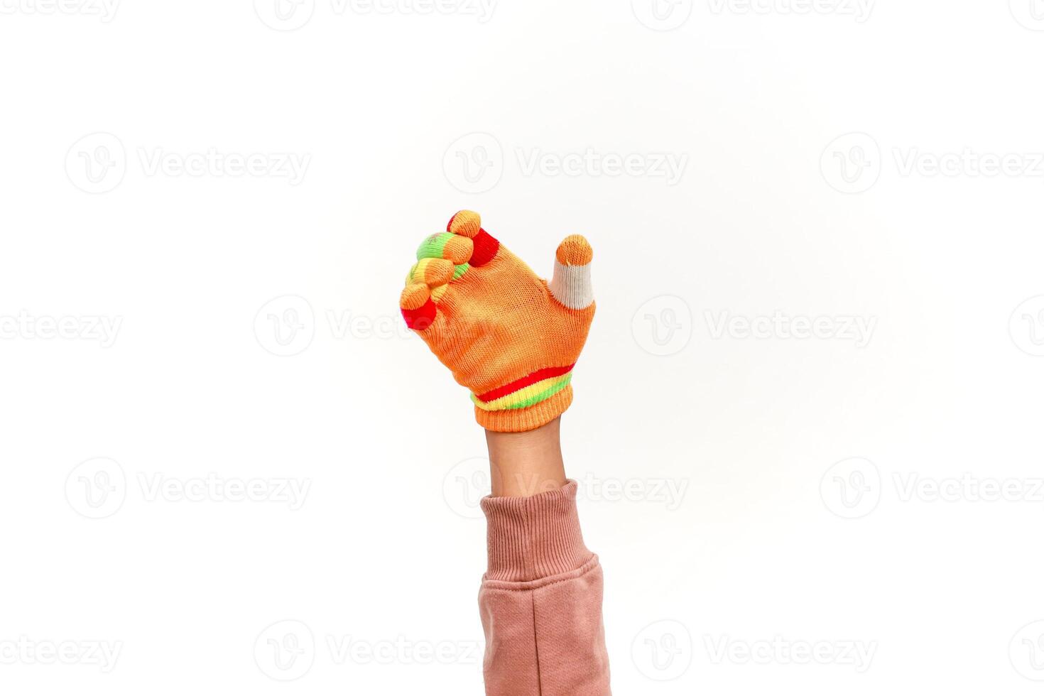 A playful hand wearing a colorful fingerless glove with a bandaged thumb reaches up high photo