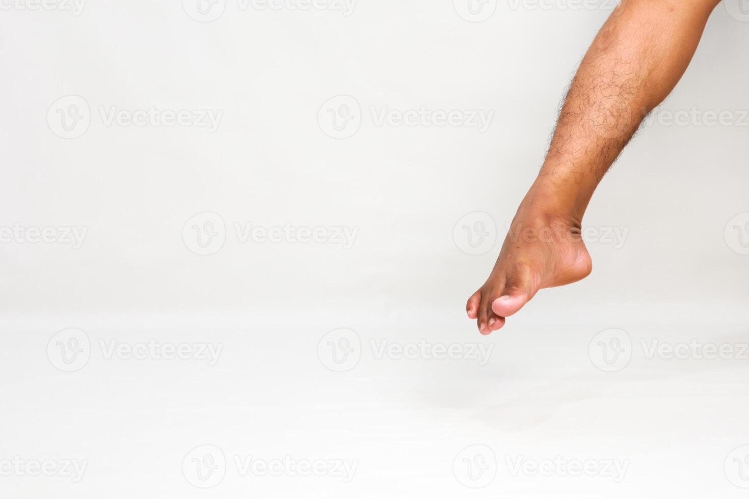 Studio shot of a person's leg, emphasizing foot dexterity and anatomy with a white background photo