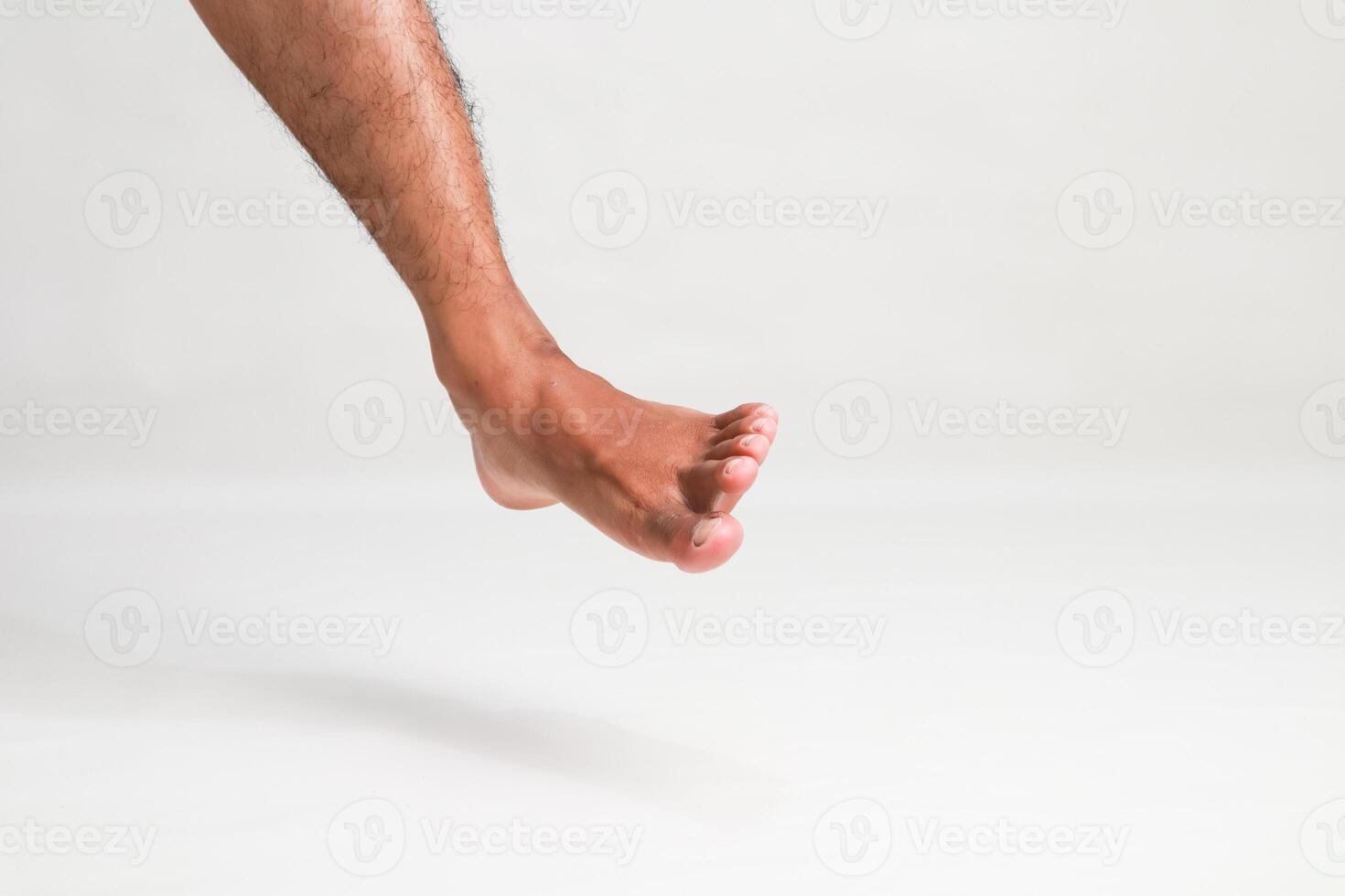 Isolated foot and leg of a man dangling with white background, showing a unique perspective of human anatomy and movement photo