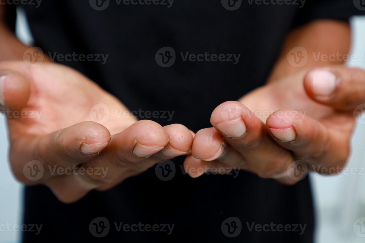 Open hands presenting, offering or receiving gesture with dark-skinned person and black shirt, isolated on white background indoors. photo