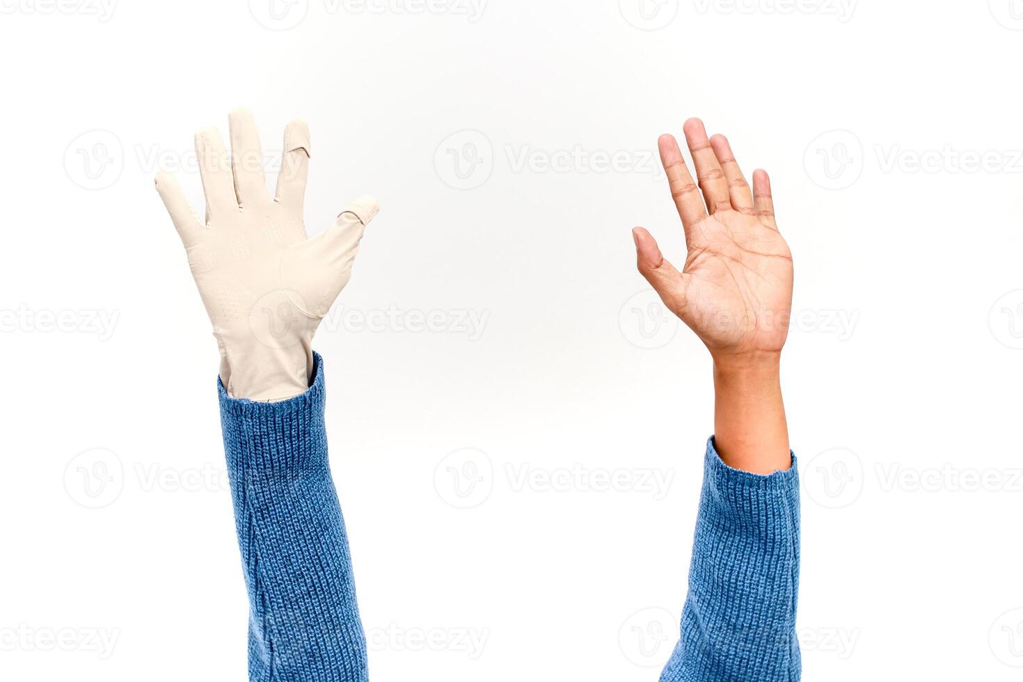 A gloved hand versus a bare hand on a white background photo