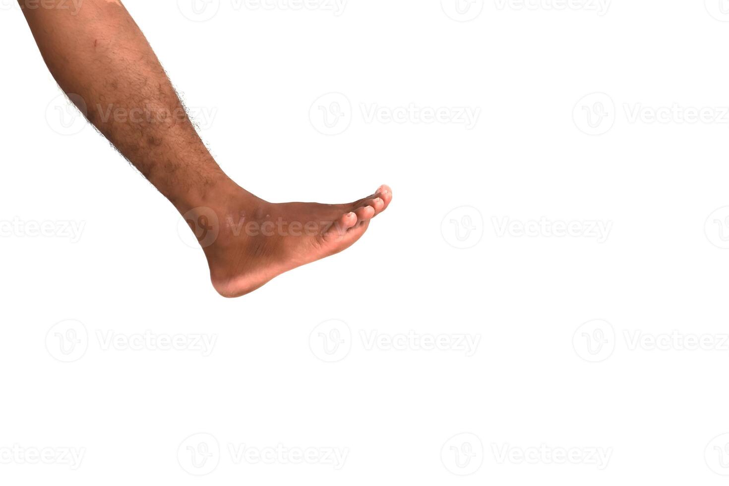 Close-up of a dark-skinned human leg and foot against a bright white background photo