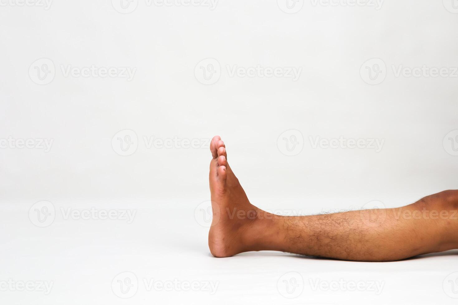 Close up of a male leg with a raised foot isolated on a white background showing foot and leg photo