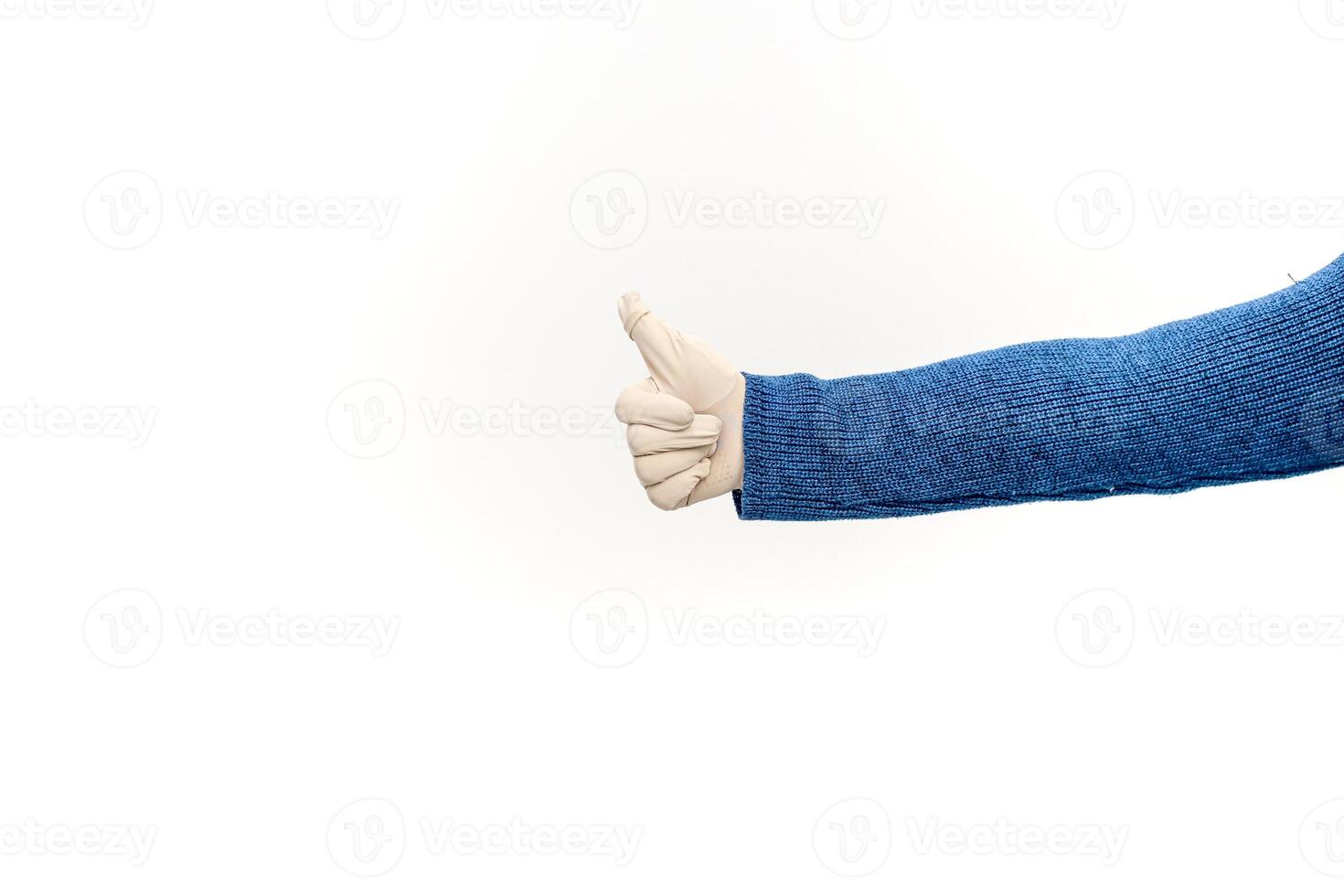 Hand in blue sweater with white glove giving thumbs up gesture on white background photo