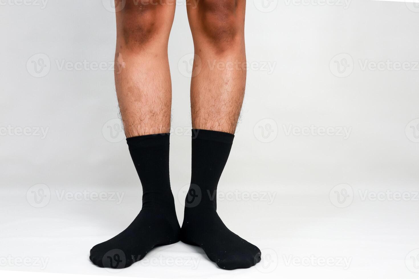 Close-up of legs and feet wearing black socks on a white background illustrating comfort photo