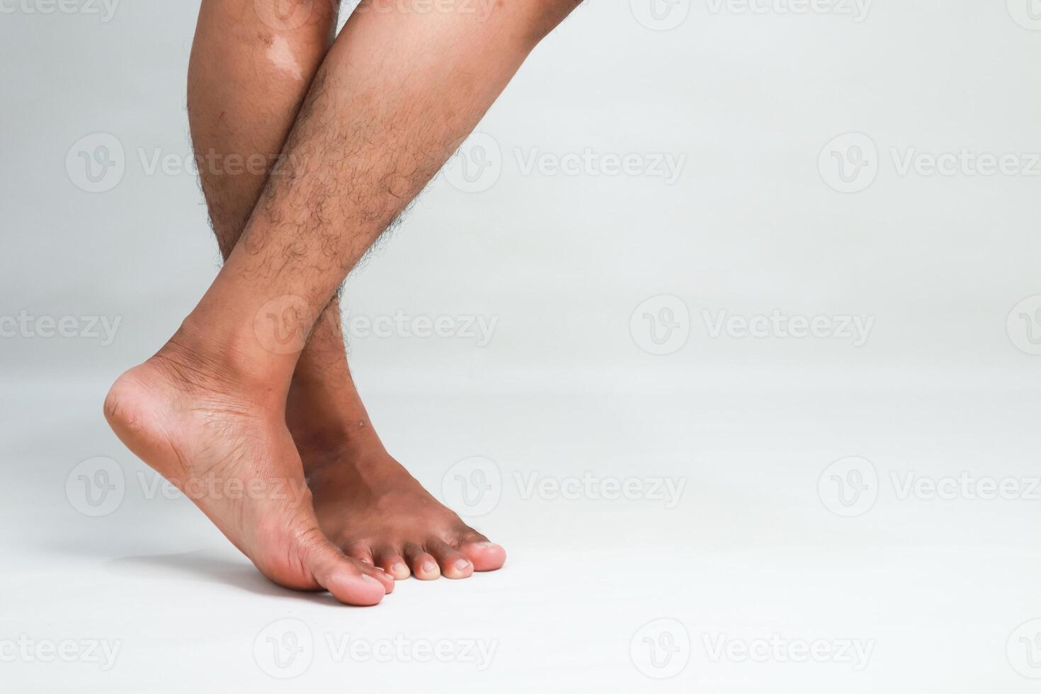 Studio shot of dark-skinned man's legs crossed, showcasing healthy skin and leg anatomy photo
