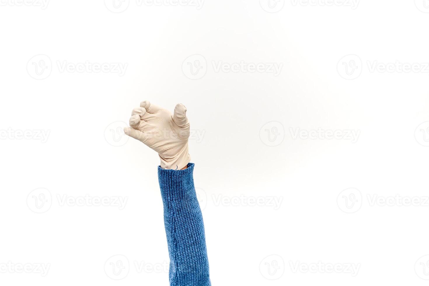 Isolated arm in a blue sweater wearing a disposable glove reaching or holding something on a white background photo