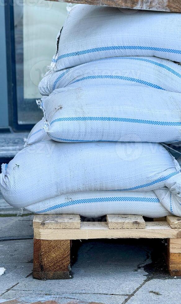 Stacked White Industrial Bags on Wooden Pallet photo