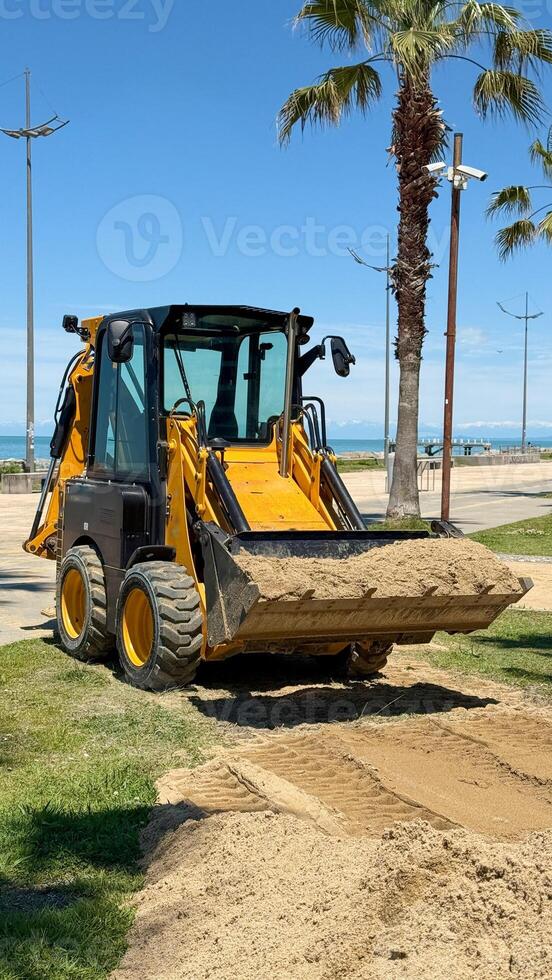 Front Loader Moving Sand in Coastal Landscape photo