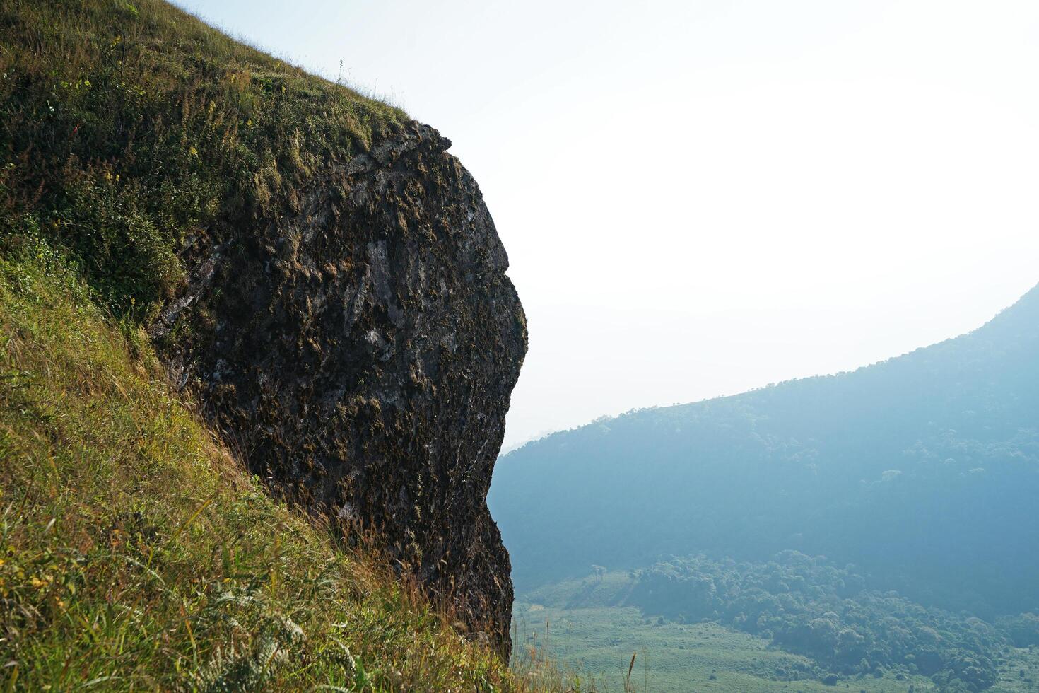 Landscape cliff of natural green mountain summit ridge with cloudy white sky photo