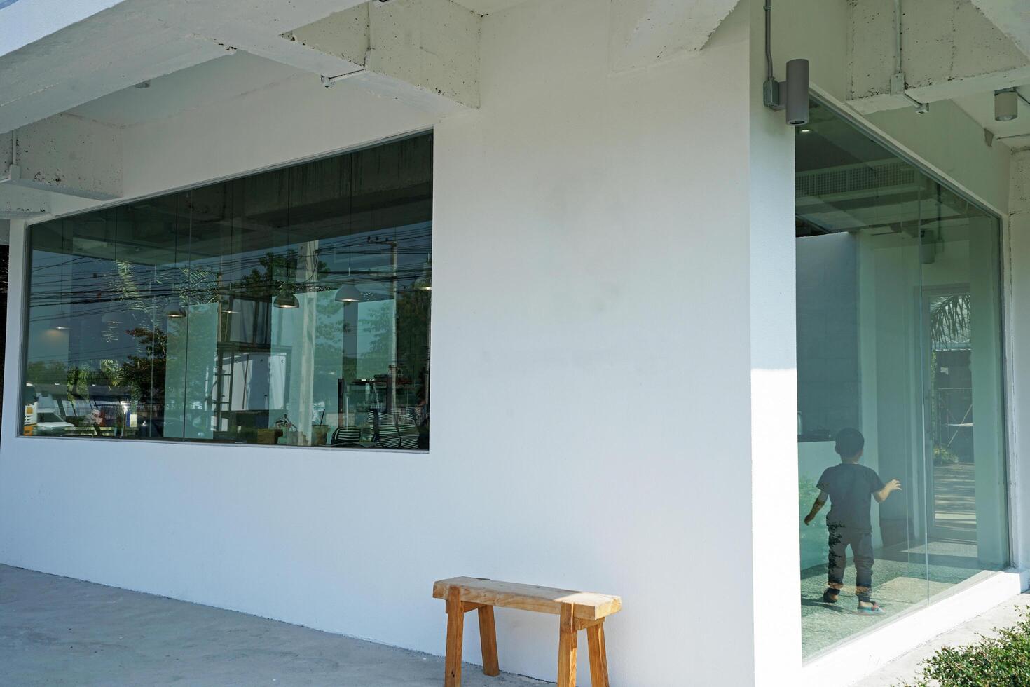 Exterior design and front store decoration of local coffee bar and bakery shop decorated with white furniture and mirror glass photo