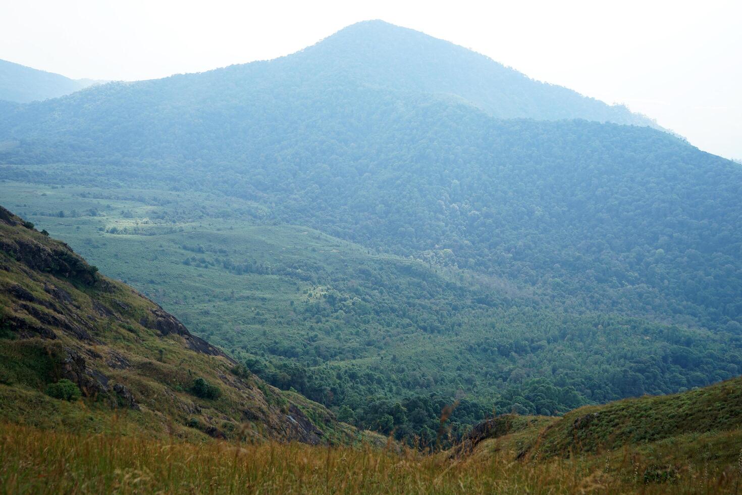 Natural scenic landscape of green hill ridge with cloudy white sky photo