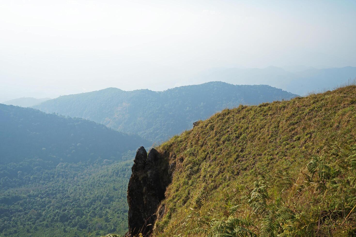 Natural scenery landscape of green hill range with cloudy white sky photo