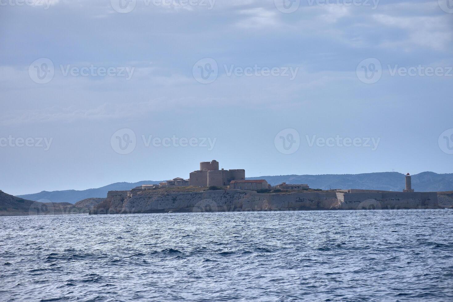 Chateau d'If on the sea horizon, a medieval structure in the Bay of Marseille with blue waters and a clear sky photo