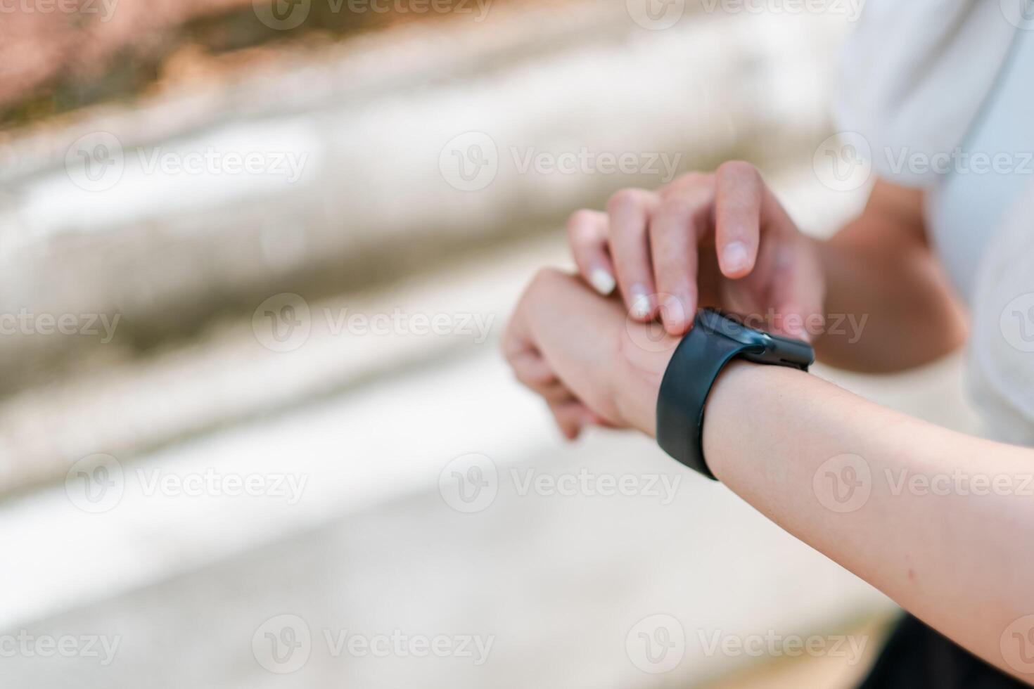 A person interacts with a smartwatch outdoors, focusing on fitness tracking and notifications. photo