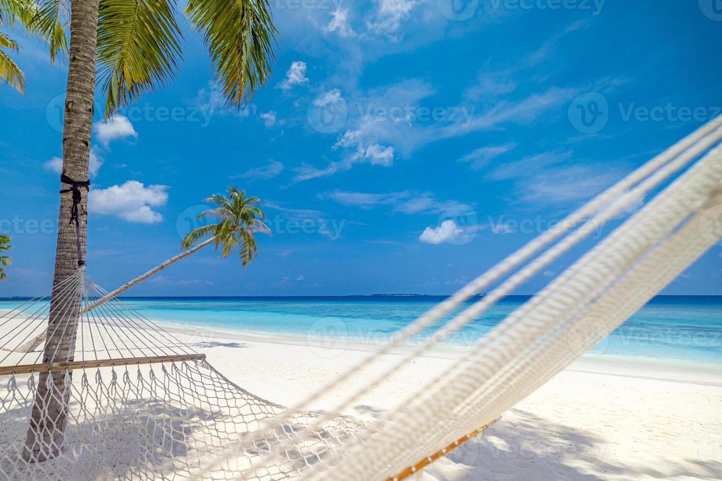 Beautiful relaxing hammock hanging between palm trees on tropical beach, peaceful serene vacation getaway, tranquil nature landscape, sunny sky, tropical island paradise, summer travel and leisure photo