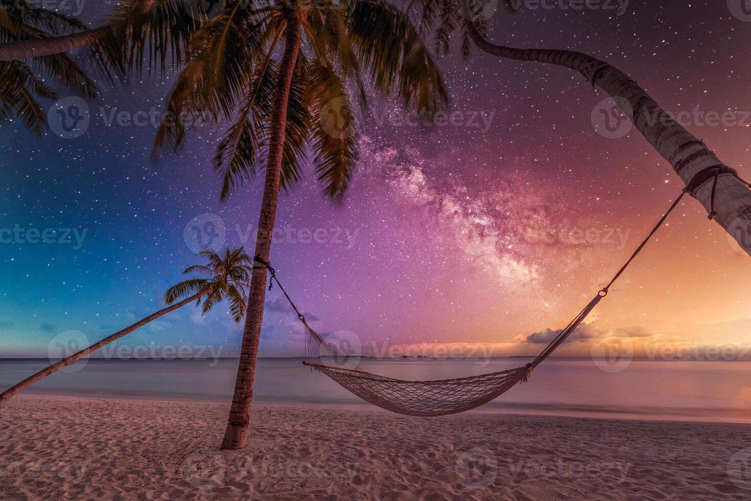 Stunning milky way night sky over hammock hanging between palm trees on tropical beach, serene peaceful vacation getaway, tranquil nature scene, starry sky tropical island paradise, outdoor relaxation photo