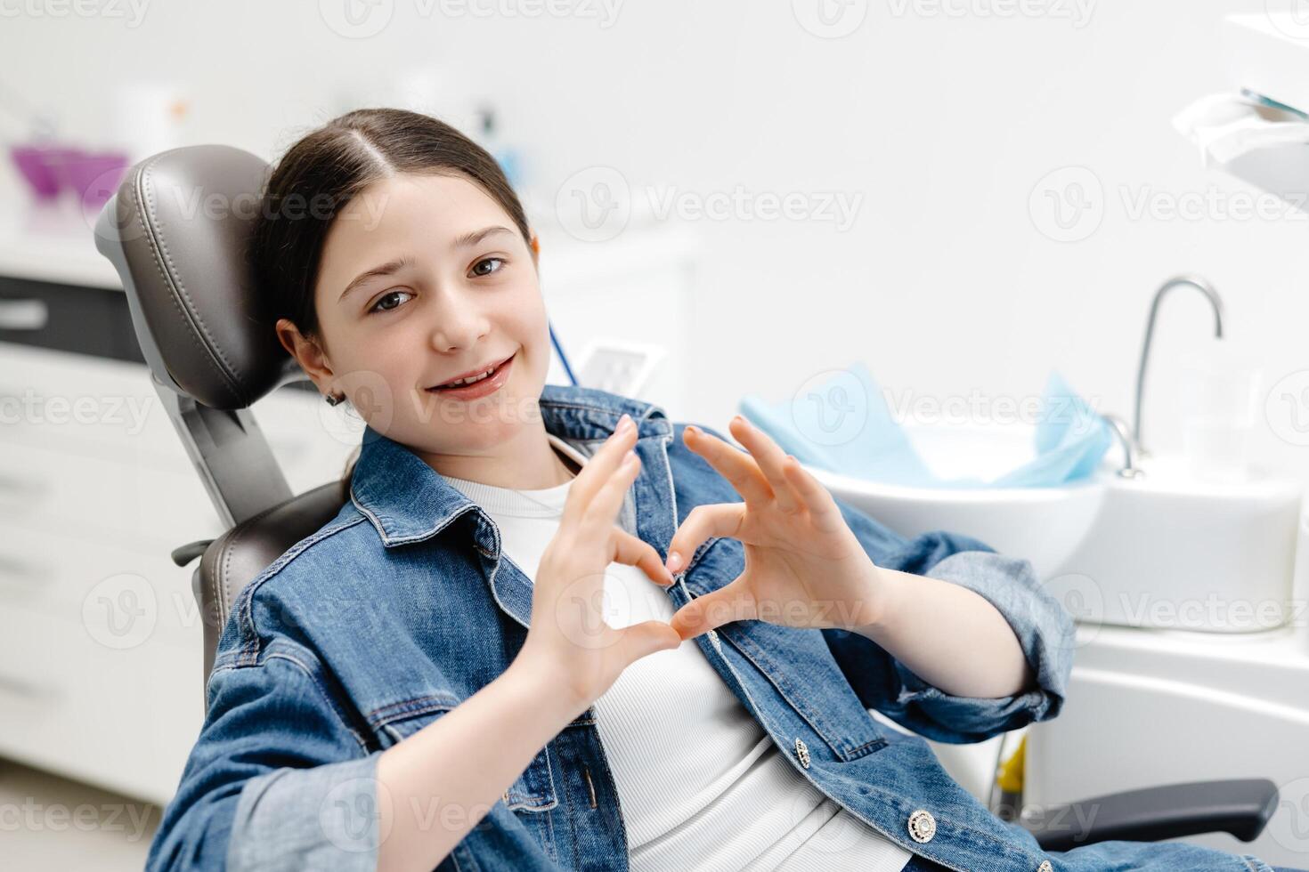 Patient Showing Heart Sign with Hands at Dentist Office. photo