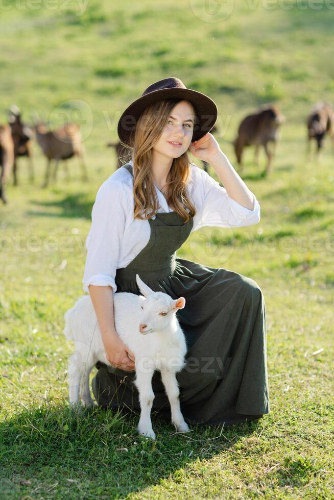 Woman with goat in a field photo